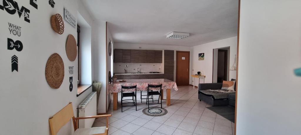 een keuken en woonkamer met een tafel en stoelen bij Stefy House in Pontebba