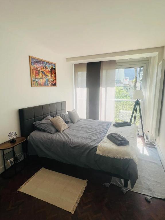 une chambre avec un grand lit avec une fenêtre dans l'établissement Nice cozy flat near Paris, à Puteaux