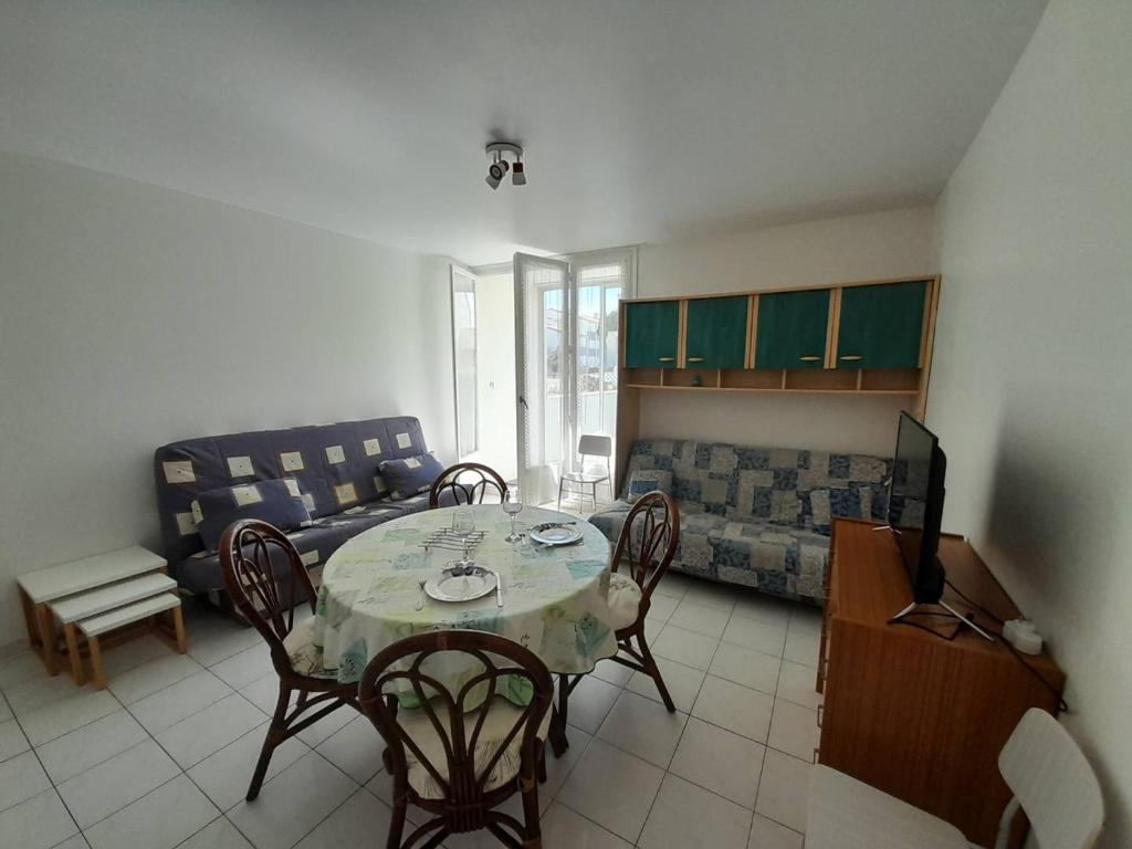 un salon avec une table, des chaises et un canapé dans l'établissement Studio cosy avec jardin, proche plage et commerces - FR-1-324A-5, à Saint-Hilaire-de-Riez
