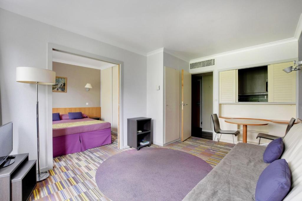 ein Schlafzimmer mit einem lila Bett und einem Tisch in der Unterkunft GuestReady - Apt moderne Paris La Défense avec AC in La Défense