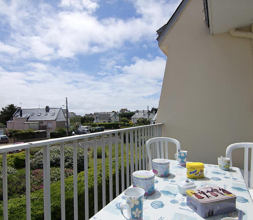 - une table sur un balcon avec vue sur la rue dans l'établissement 3 pièces centre ville, 4 min à pied plage, parking, wifi, à Quiberon