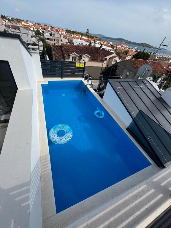 a large blue swimming pool on the roof of a house at Vila Ibrahimovic Vodice in Vodice