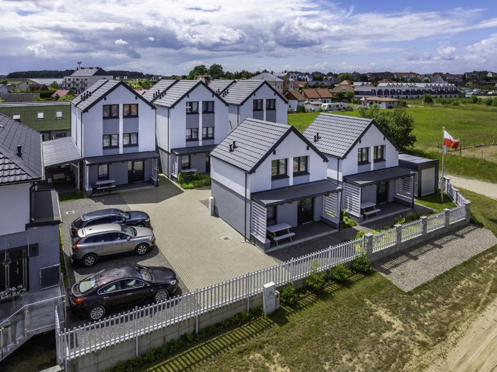 an aerial view of a row of houses at FRAJDA Domki - Apartamenty 6-osobowe - salon i dwie sypialnie oraz Studia 4-osobowe - pokój z aneksem kuchennym in Rewal