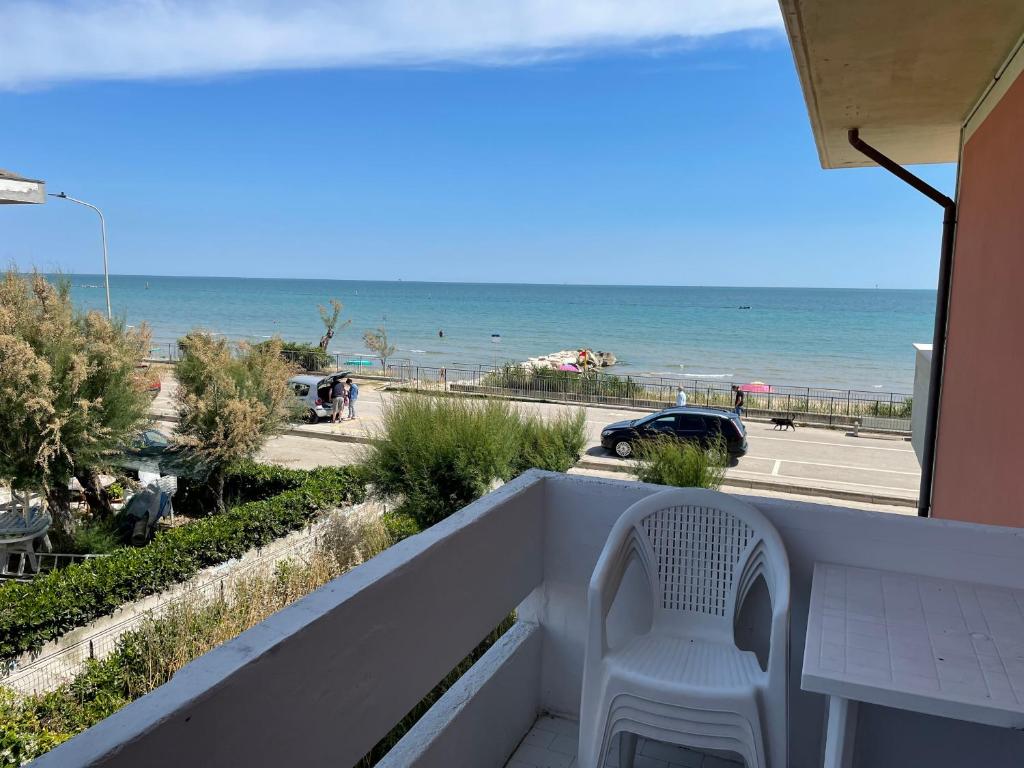 a white chair sitting on a balcony overlooking the beach at Silville in Silvi Marina