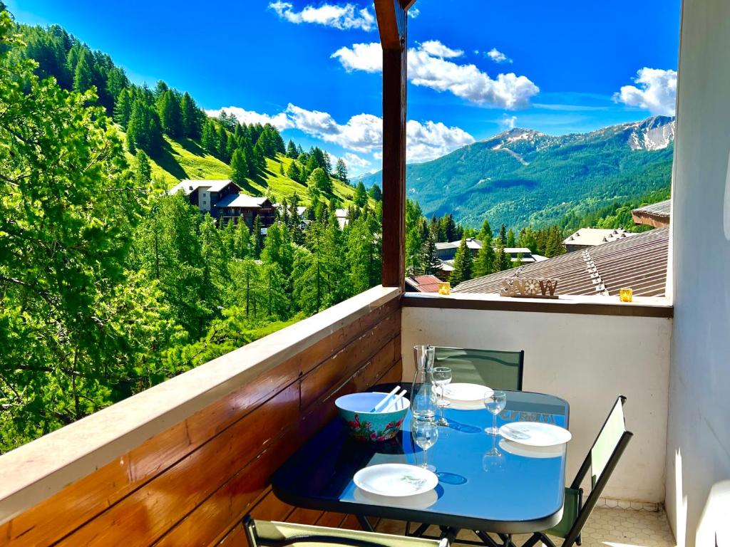 d'une table sur un balcon avec vue sur les montagnes. dans l'établissement Appartement familial Duplex La Foux d'Allos au pied du télésiège, à Allos
