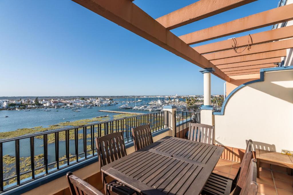 ein Balkon mit Tisch und Stühlen und Blick auf das Wasser in der Unterkunft Marina II by Ĥ - Marina Isla Canela PMHII27P65 in Punta del moral