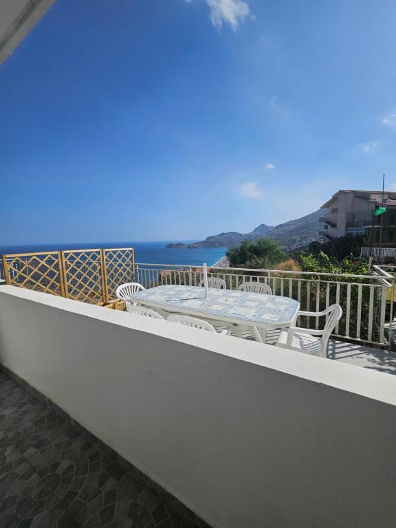 a balcony with a table and chairs and the ocean at Casa Yuliya in Letojanni