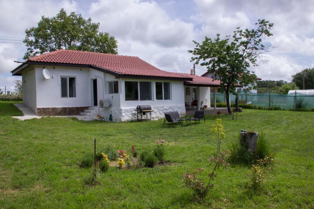 ein kleines weißes Haus auf einem Grasfeld in der Unterkunft Vintage House Prima Priori in Vaklino