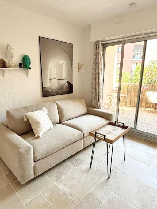 un salon avec un canapé et une table dans l'établissement Studio centre ville- Grand balcon-Meublé BoConcept, à Cavalaire-sur-Mer