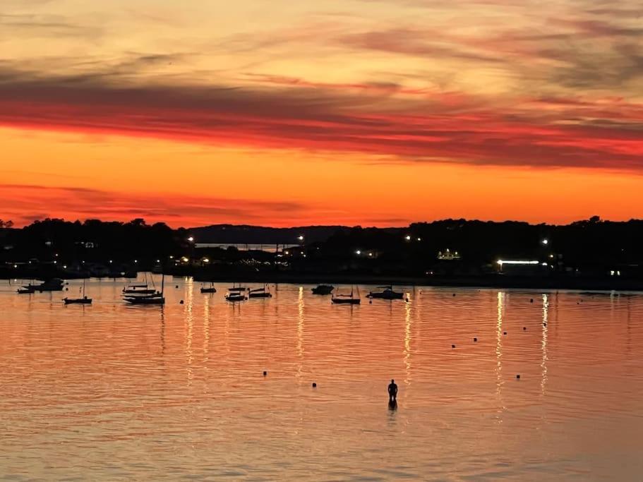 une personne debout dans l'eau au coucher du soleil dans l'établissement VILLA NIKITA Plage, à Andernos-les-Bains