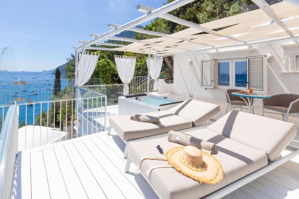 a balcony with white furniture and a view of the ocean at Villa Nannina in Positano