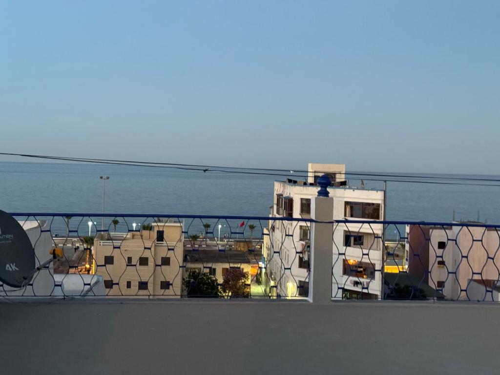 ein Balkon mit Blick auf ein Gebäude und das Meer in der Unterkunft Maison oudelaou in Oued Laou