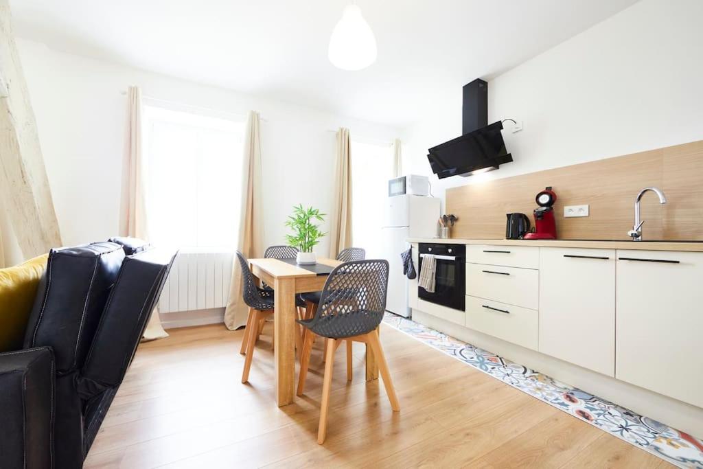 une cuisine avec une table et des chaises dans une pièce dans l'établissement RB-2D - Appartement F2 au 2ème étage à Mulhouse de 1 à 3 pers, à Mulhouse