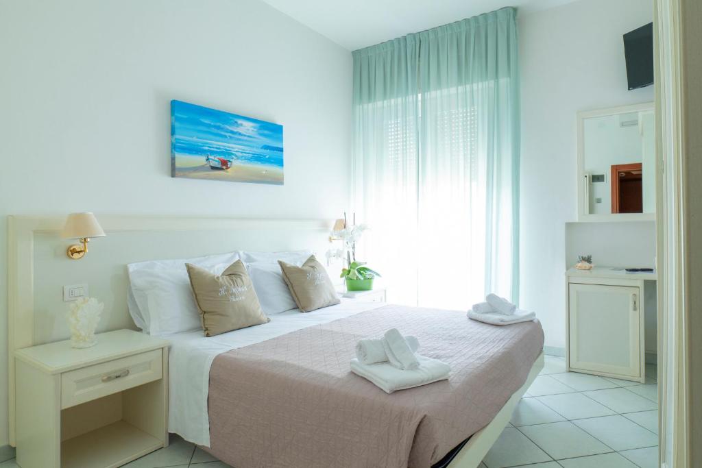 sypialnia z łóżkiem i dwoma ręcznikami na nim w obiekcie Hotel Negresco w mieście Riccione