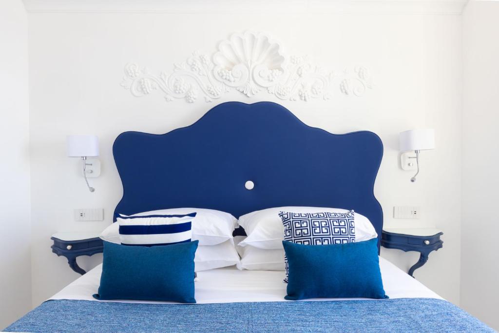 a blue and white bed with blue and white pillows at Villa Nannina in Positano