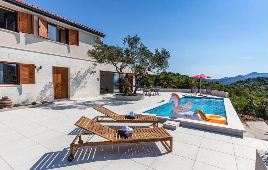 una piscina con 2 bancos y una piscina en Gorgeous Home In Ploce, en Ploče