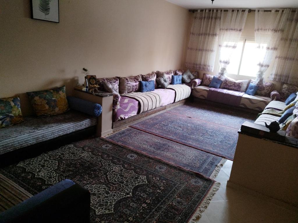 ein Wohnzimmer mit Sofas und einem Teppich in der Unterkunft رقم 1 عملية باب g العزوزية مراكش in Marrakesch