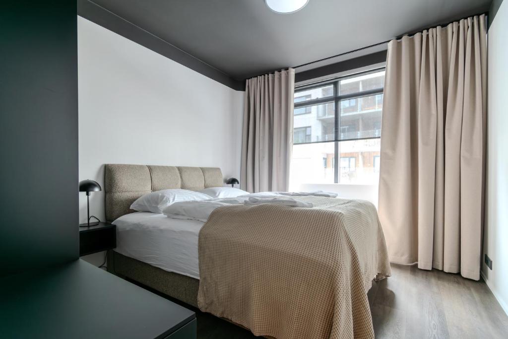 une chambre avec un lit et une grande fenêtre dans l'établissement B2 Apartments by Heimaleiga, à Reykjavik