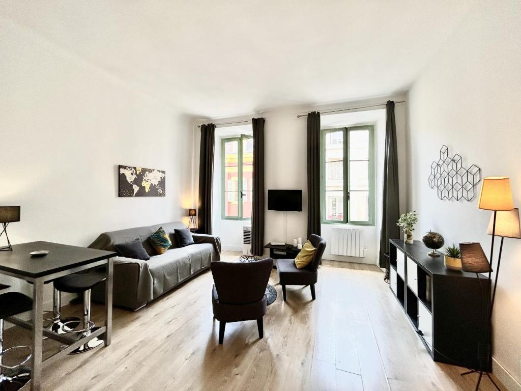 un salon avec un canapé et une table dans l'établissement ApartHotel Riviera - Villa Massena - Grimaldi Promenade des Anglais, à Nice