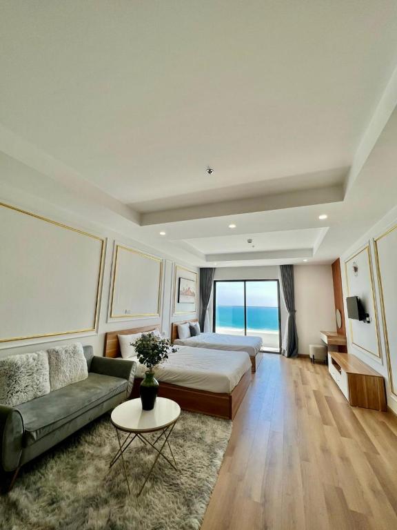 a hotel room with a bed and a couch at Căn hộ TMS Quy Nhơn KIM NGÂN in Quy Nhon