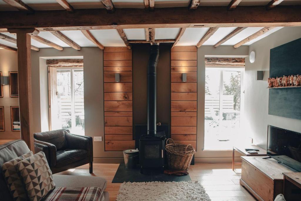 un soggiorno con una parete rivestita in legno con una stufa di THE OLD DAIRY at Sunny Brow Farm ad Ambleside