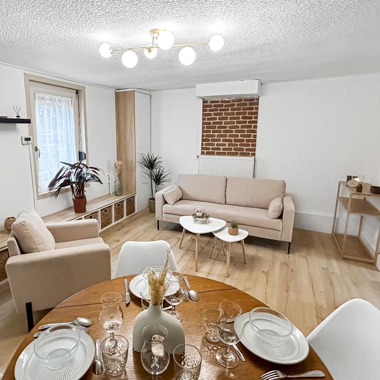 un salon avec une table et un canapé dans l'établissement Séjour Élégant à la Porte de Lille, à Seclin