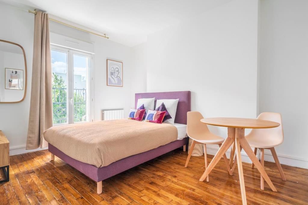 une chambre avec un lit et une table dans l'établissement Studio paisible en banlieue parisienne - Montreuil, à Montreuil