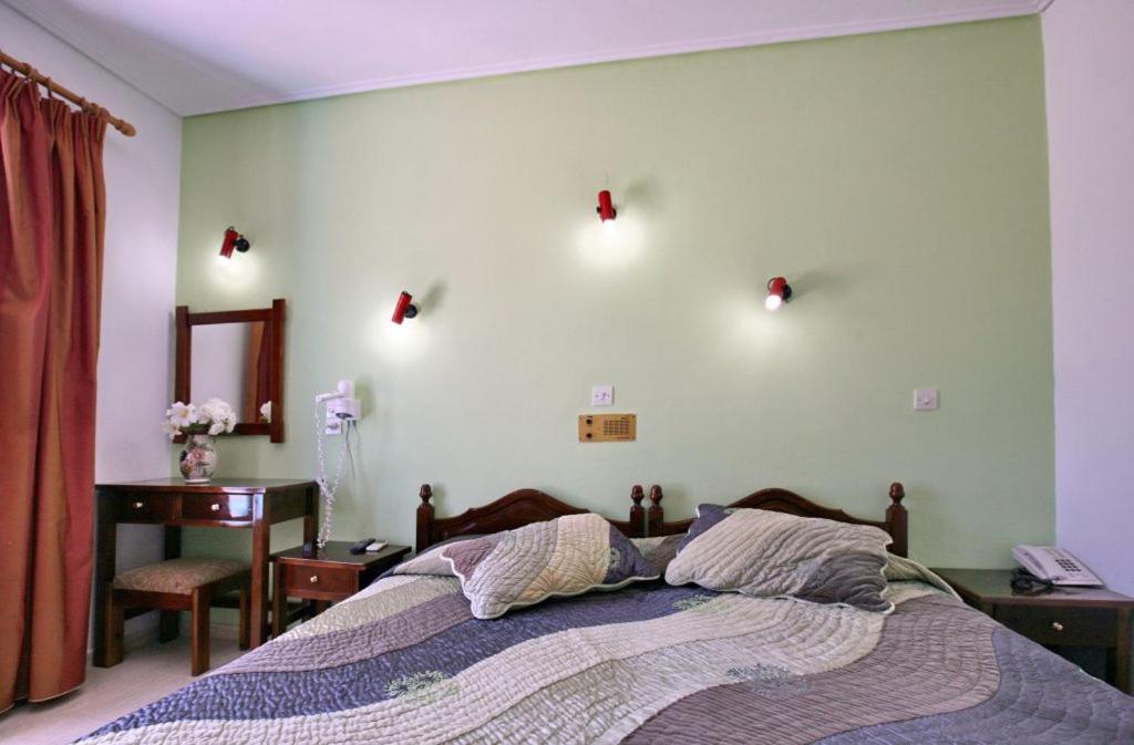 A bed or beds in a room at Theofilos Classic Hotel