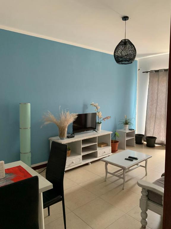 un soggiorno con una tv e un tavolo di Vannimar t2 a Porto Novo