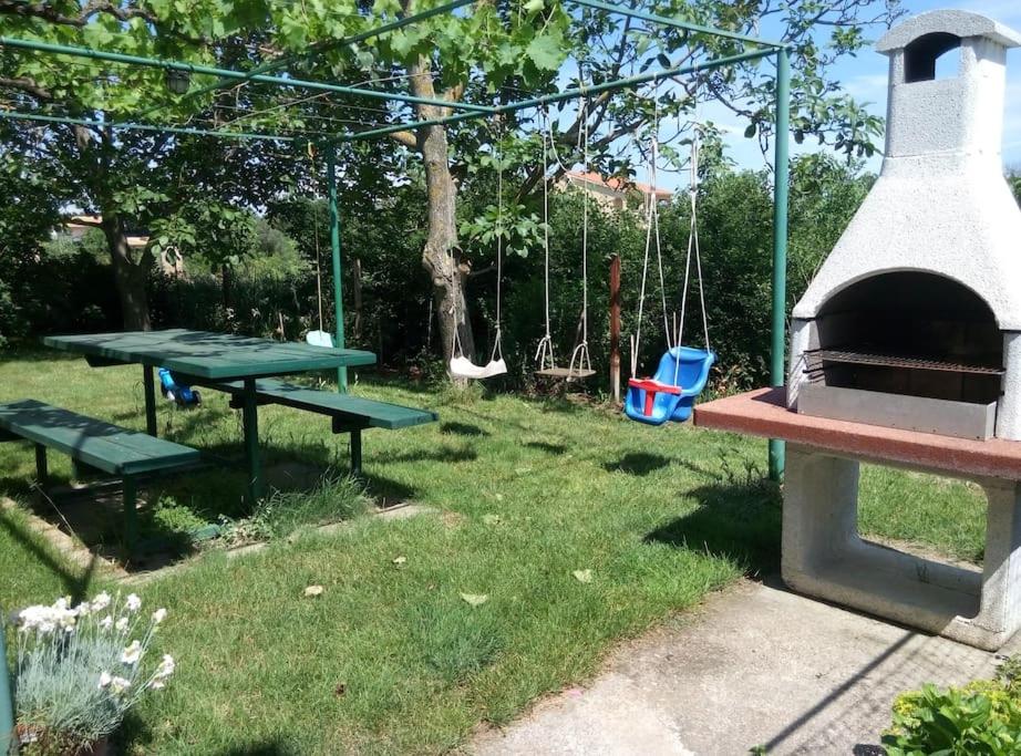 a park with a picnic table and a swing at Apartman Nela Banjole in Banjole