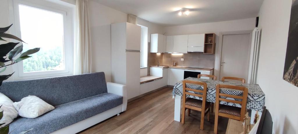 a living room with a couch and a table and a kitchen at Erica in Folgaria