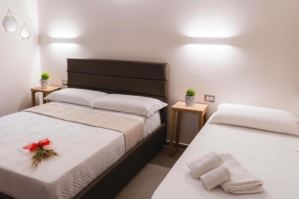 a bedroom with two beds with a red bow on them at Art Boutique Rooms in Le Castella