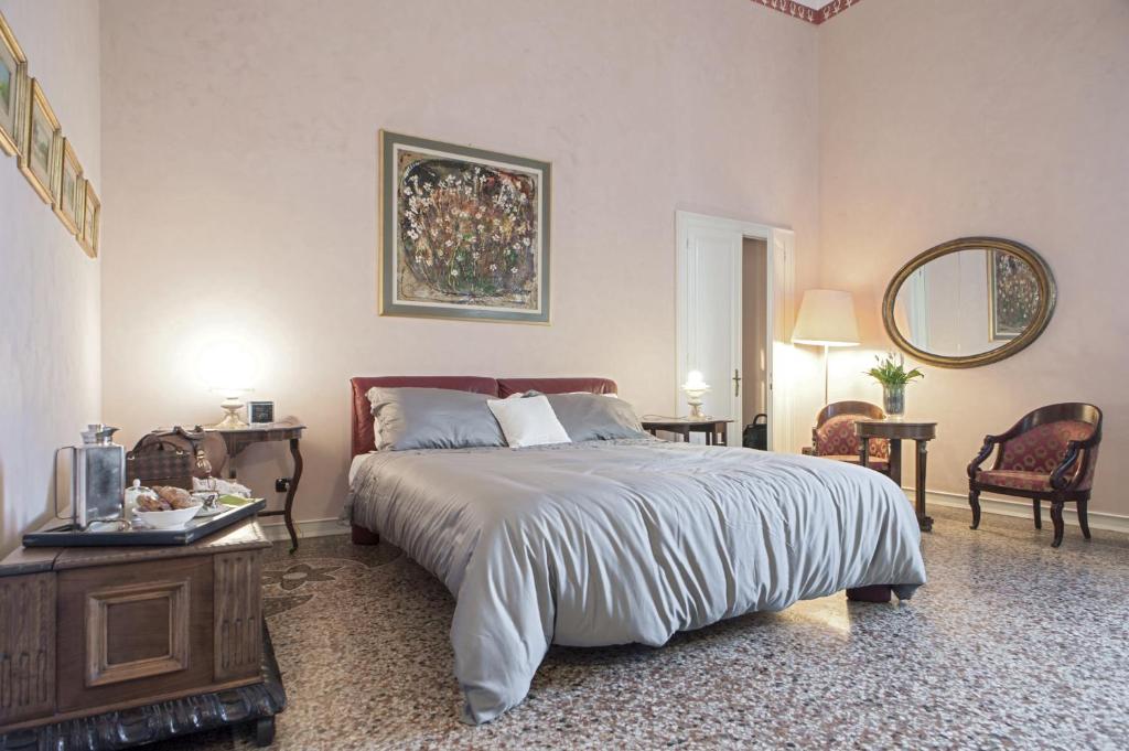 リヴォルノにあるDimora Storica Ai Casini D'ardenza B&Bのベッドルーム1室(ベッド1台、テーブル、椅子付)