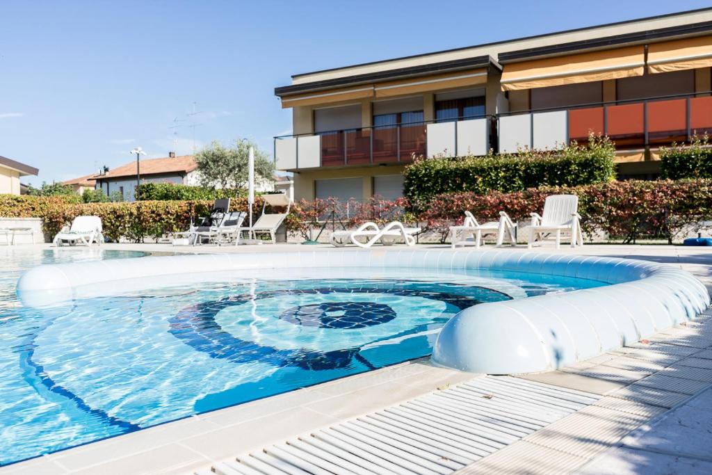 a swimming pool in front of a building at Mazzarona Family Apartment - Luminoso appartamento con piscina al secondo piano in Sirmione