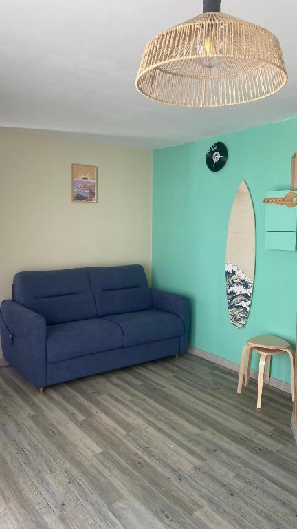 un salon avec un canapé bleu et un miroir dans l'établissement Appartement bord de mer Palavas, à Palavas-les-Flots