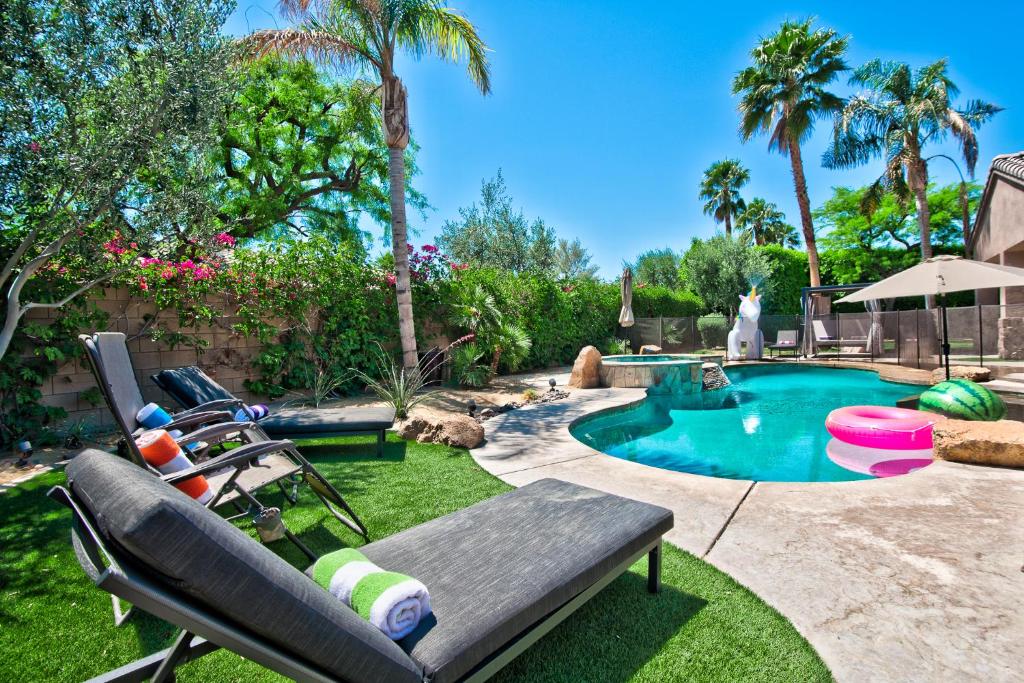 a backyard with a swimming pool with a bench and a chaise lounge at Casa Serenity - Luxury Living w Pool & Jacuzzi in Indio