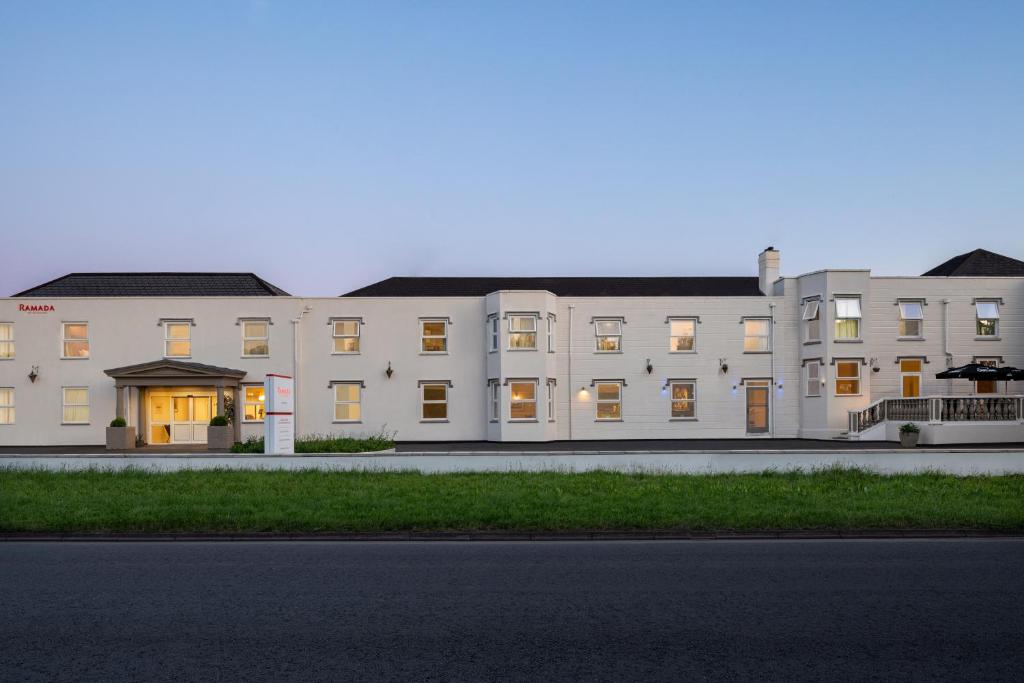 a large white building with a street in front of it at Ramada by Wyndham Cheltenham in Cheltenham