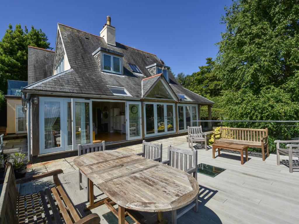 a patio with a wooden table and chairs at Dove Cottage in Dittisham