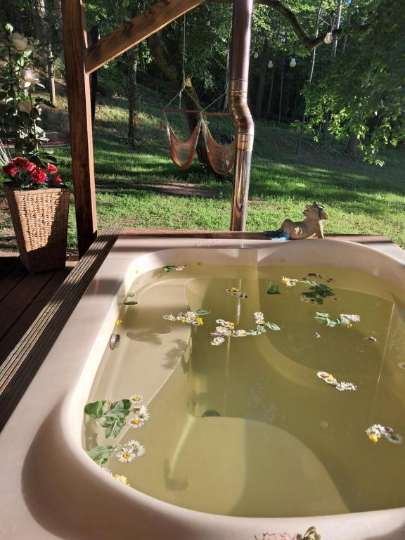 a bath tub filled with water in a yard at Koka namiņš "Pasaka" in Vecumnieki