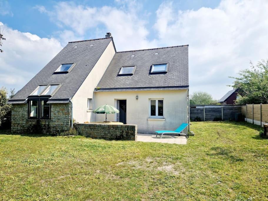 une maison avec un banc bleu dans une cour dans l'établissement Villa Ludi, à Portbail