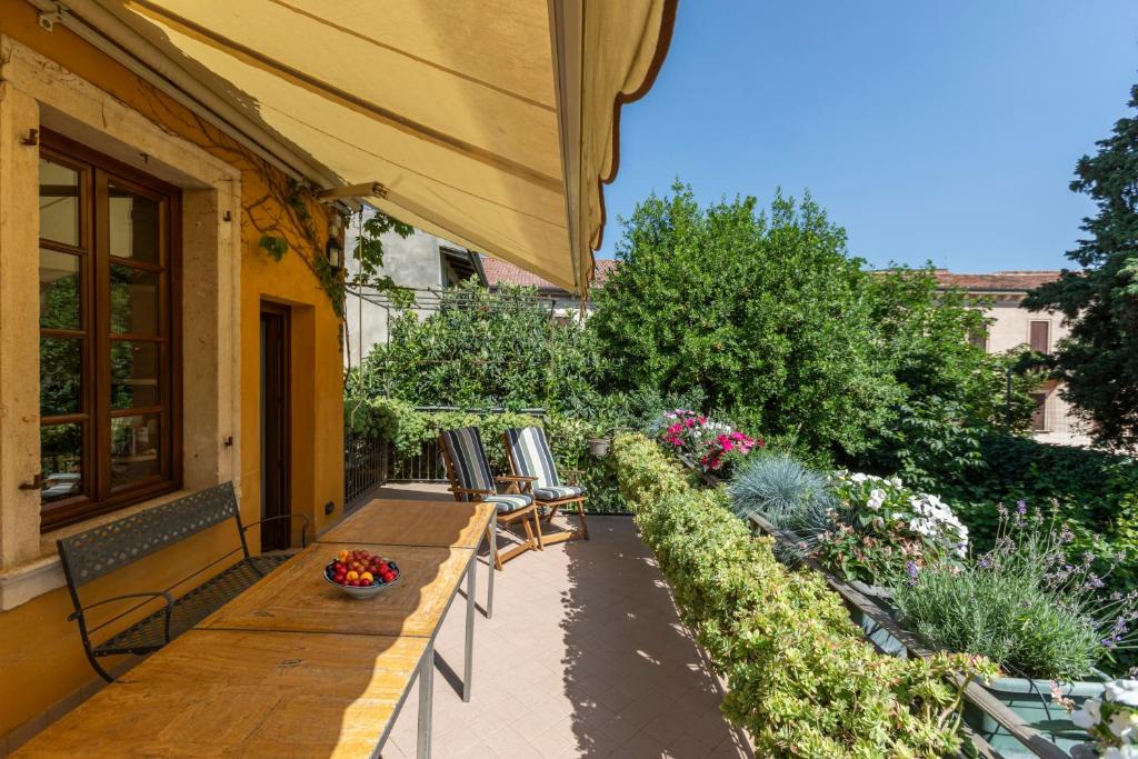un patio con 2 bancos y un jardín en Giardino Giusti Home, en Verona