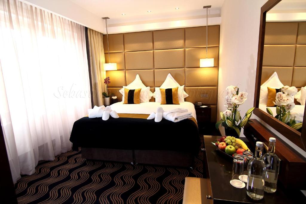 a hotel room with a bed and a mirror at The Piccadilly London West End in London
