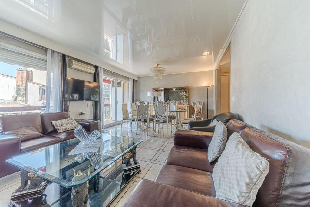 un salon avec un canapé et une table en verre dans l'établissement Spacious 3-bedroom apartment with balcony Gratte Ciel Villeurbanne, à Villeurbanne