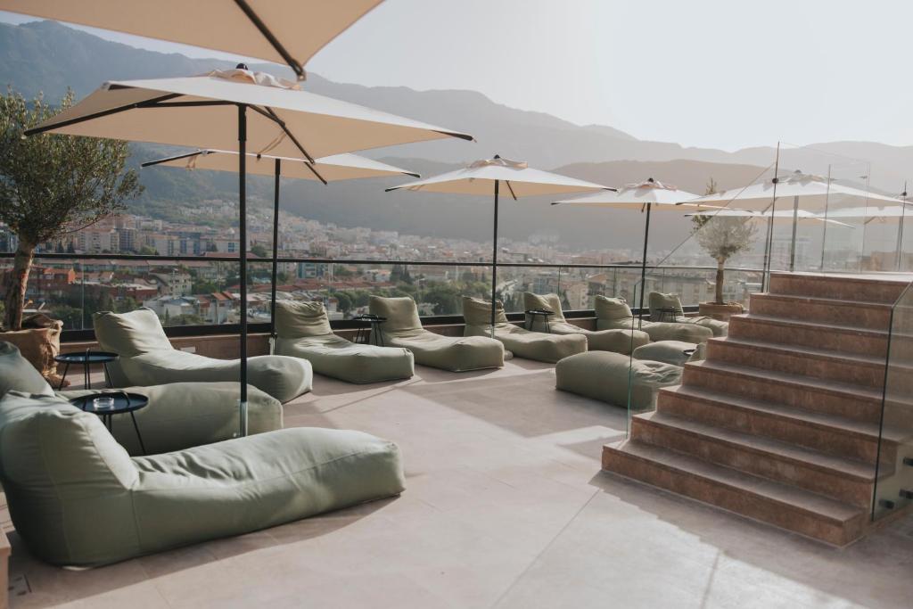 a row of couches and tables and umbrellas at Infinity Hotel & More in Budva
