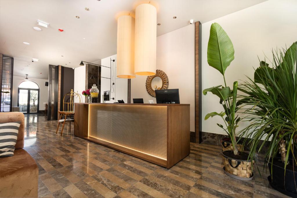 a lobby with a reception desk and potted plants at Infinity Hotel & More in Budva