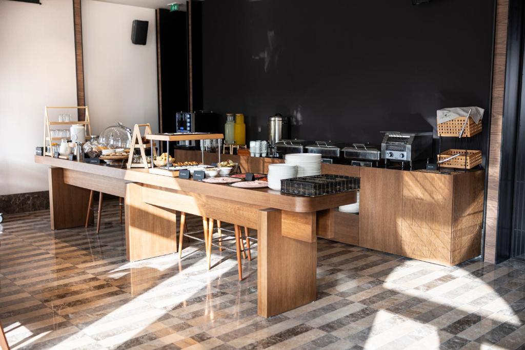 a kitchen with a counter with wooden tables at Infinity Hotel & More in Budva