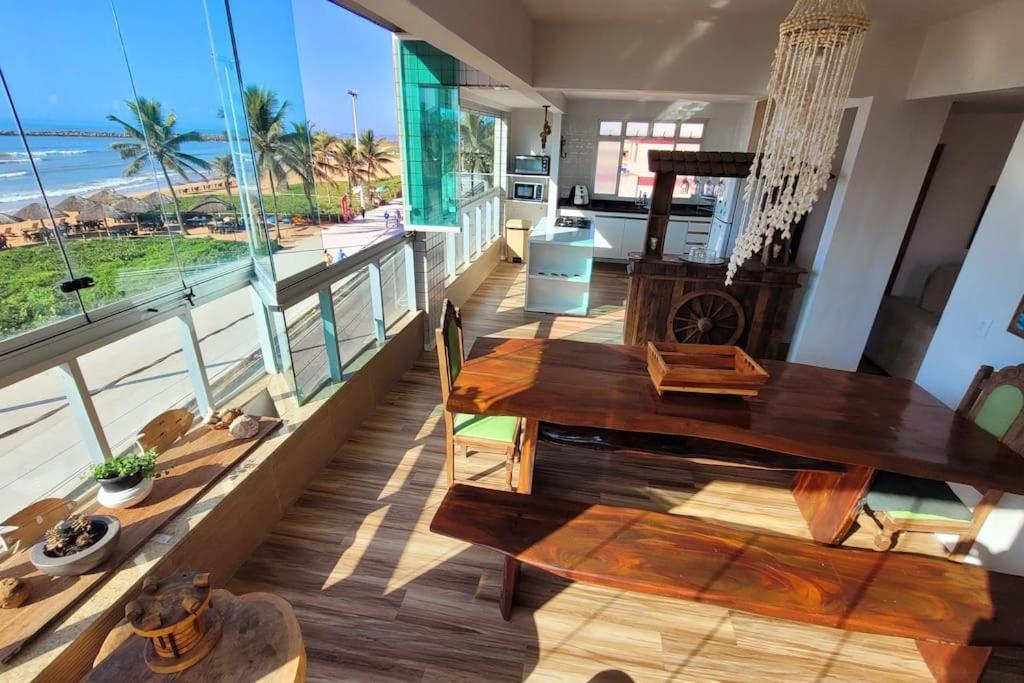une salle à manger avec une table et une vue sur l'océan dans l'établissement Lindo apto de frente para o mar, à Serra