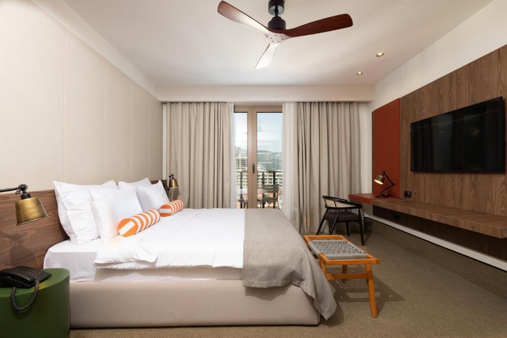 a bedroom with a bed and a flat screen tv at Infinity Hotel & More in Budva