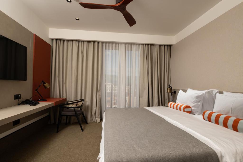 a hotel room with a large bed and a desk at Infinity Hotel & More in Budva