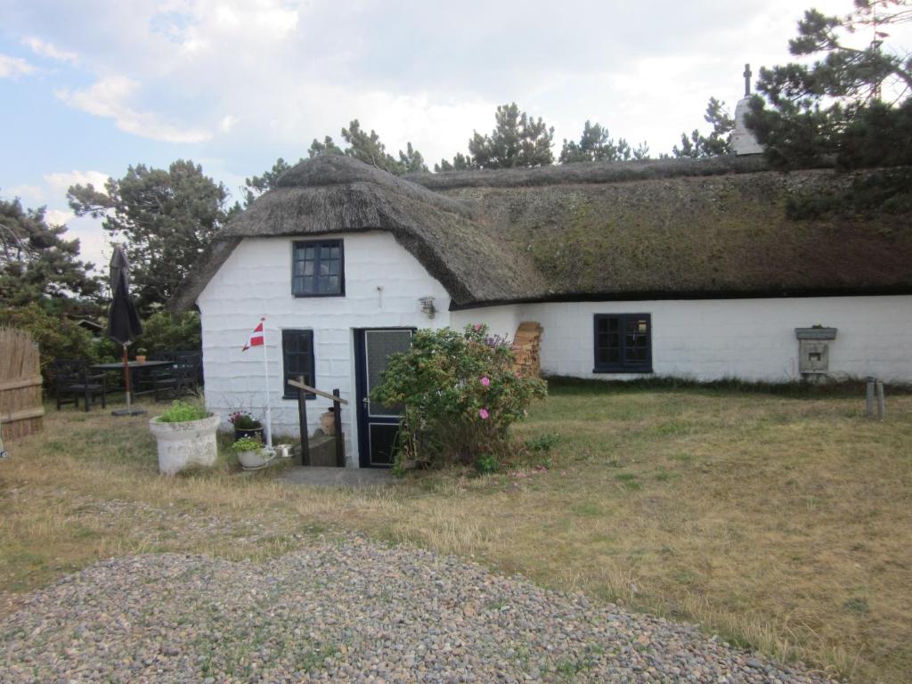 a thatched cottage with a thatched roof at Apartment Holmsland in Hvide Sande